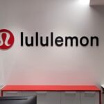 Lululemon logo on modern white wall interior with red counter