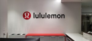 Lululemon logo on modern white wall interior with red counter