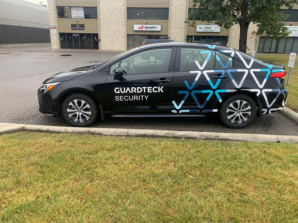 Vinyl Vehicle Wraps - 4-door sedan with a partial vehicle wrap and decals for Guardtek Security