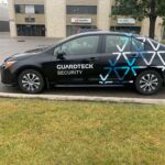 4-door sedan with a partial vehicle wrap and decals for Guardtek Security